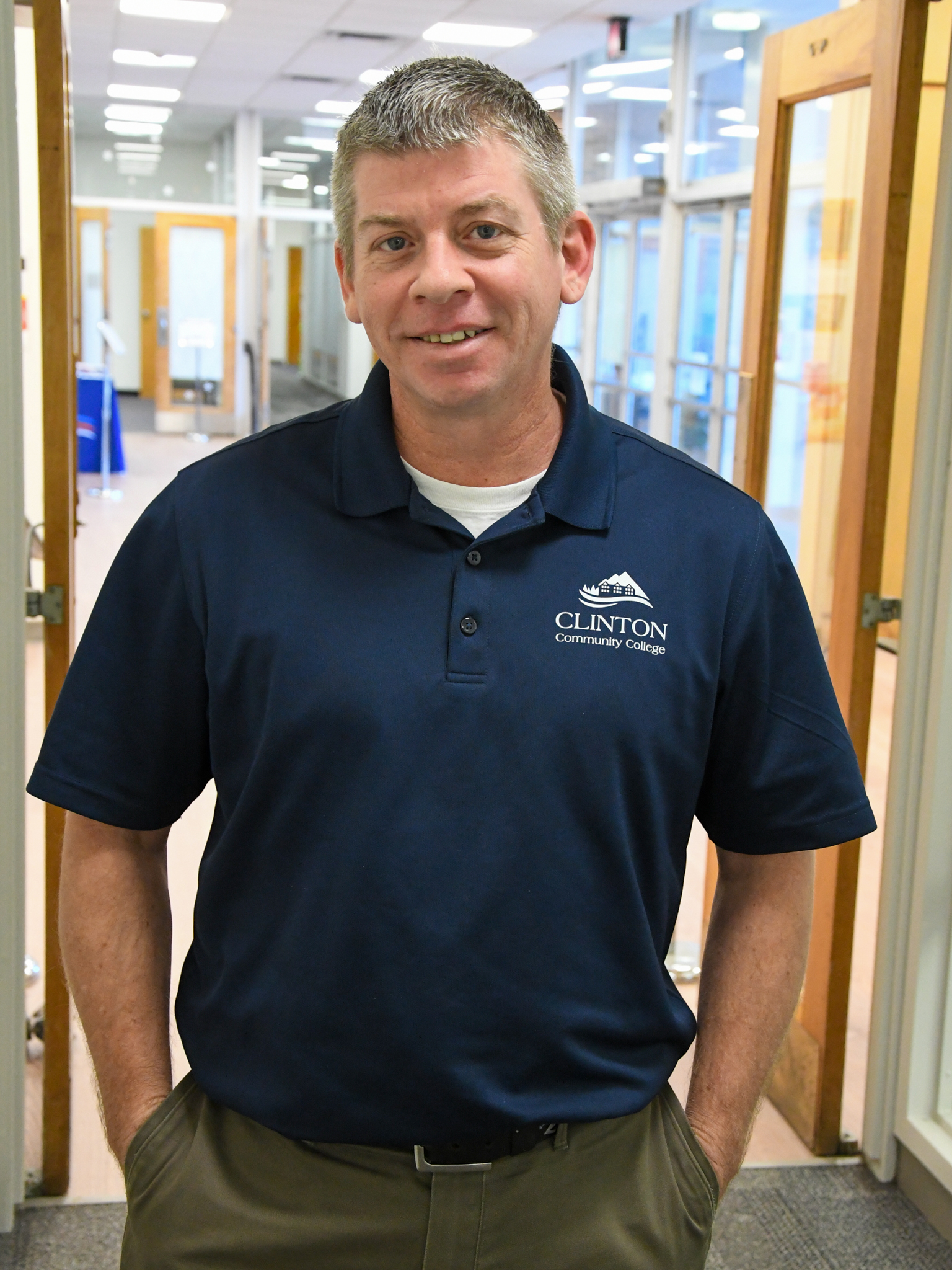 A man smiling for a photo while standing in a lobby