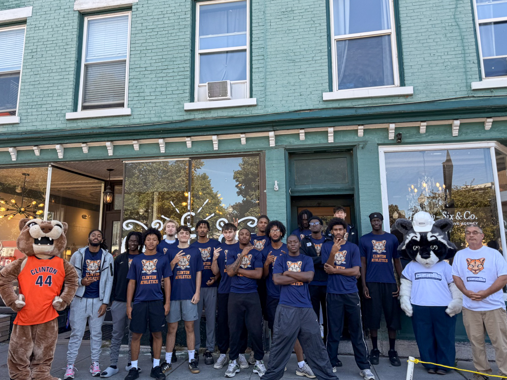 A basketball team posing next to two mascots