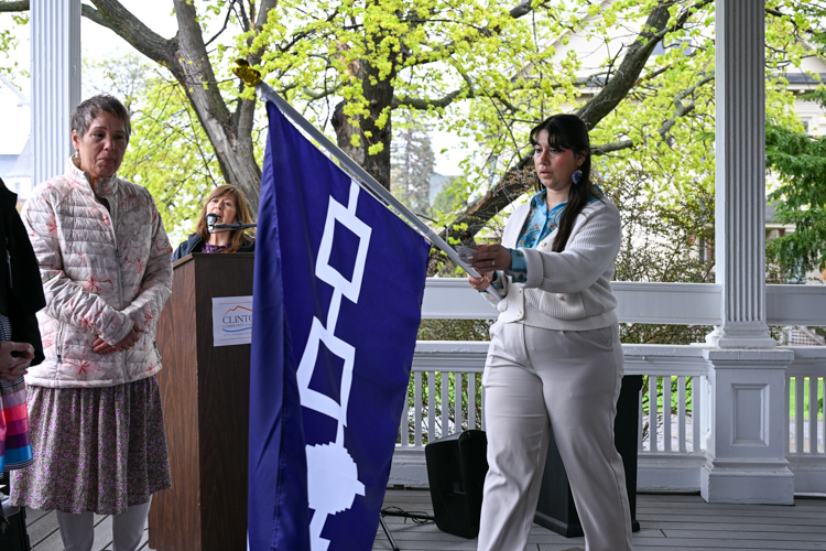 A woman carries the Haudenosaunee flag as others watch