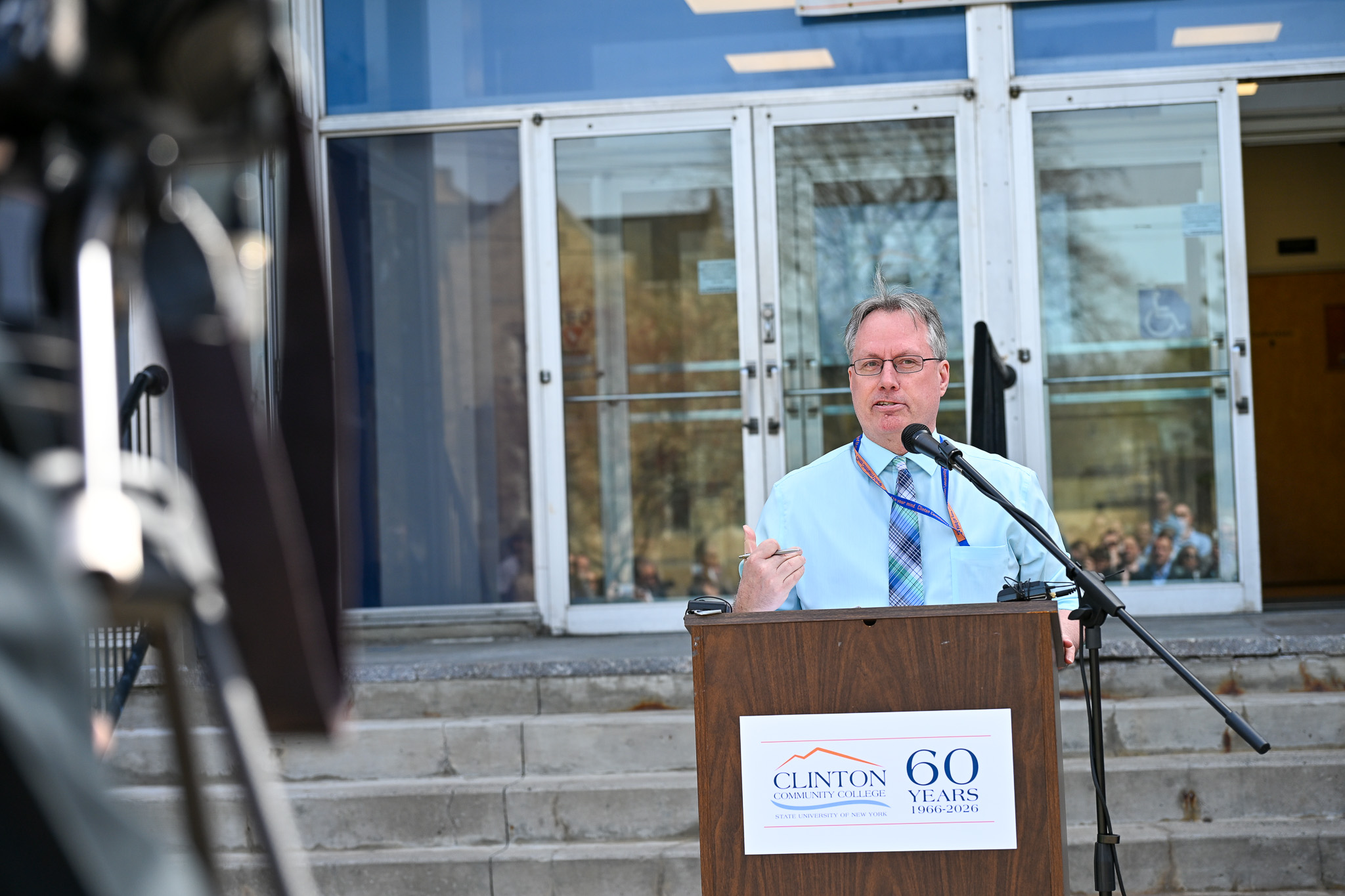A man speaking at a podium with a Clinton Community College sign