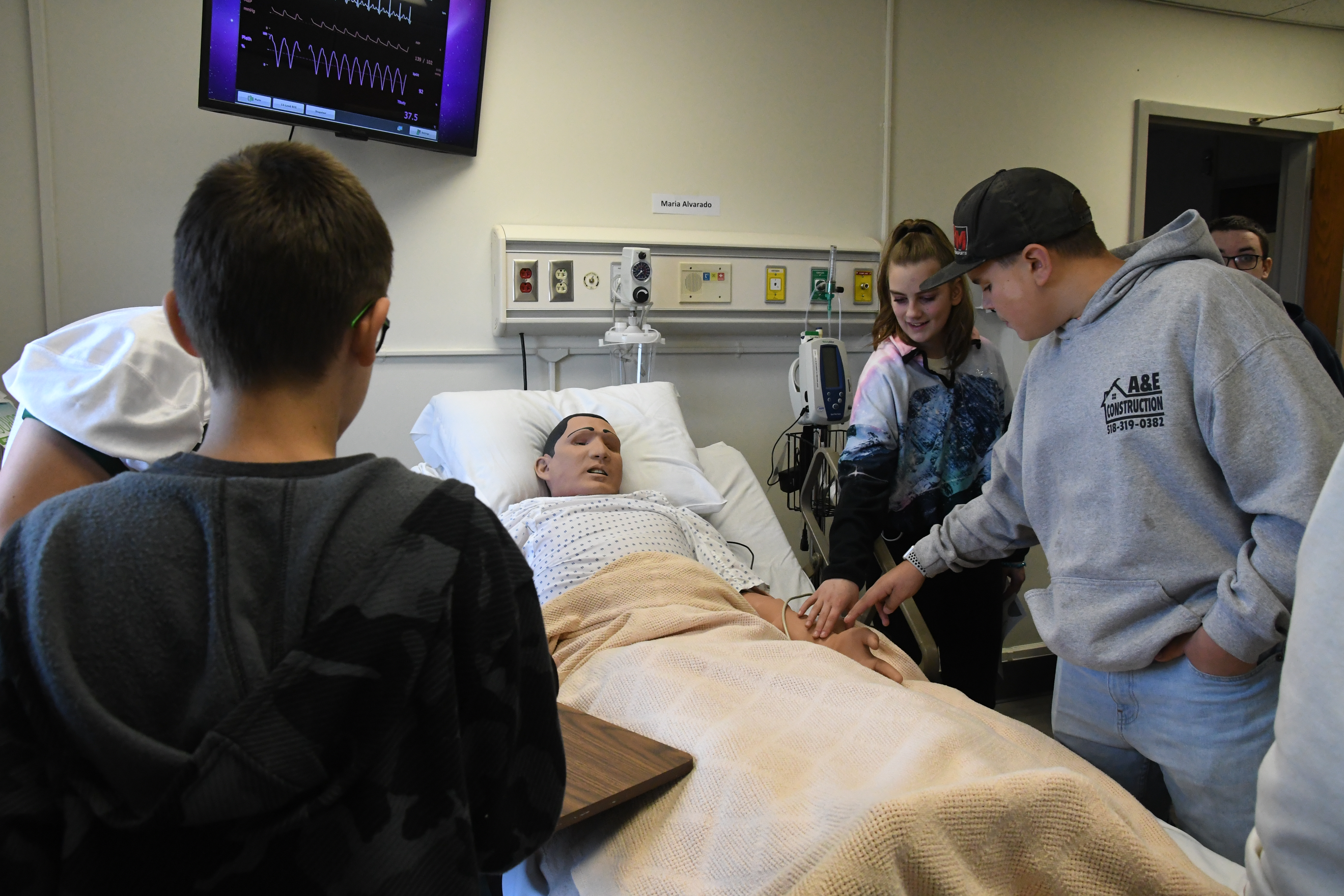 Malone students interacting with a nursing animatronic. 