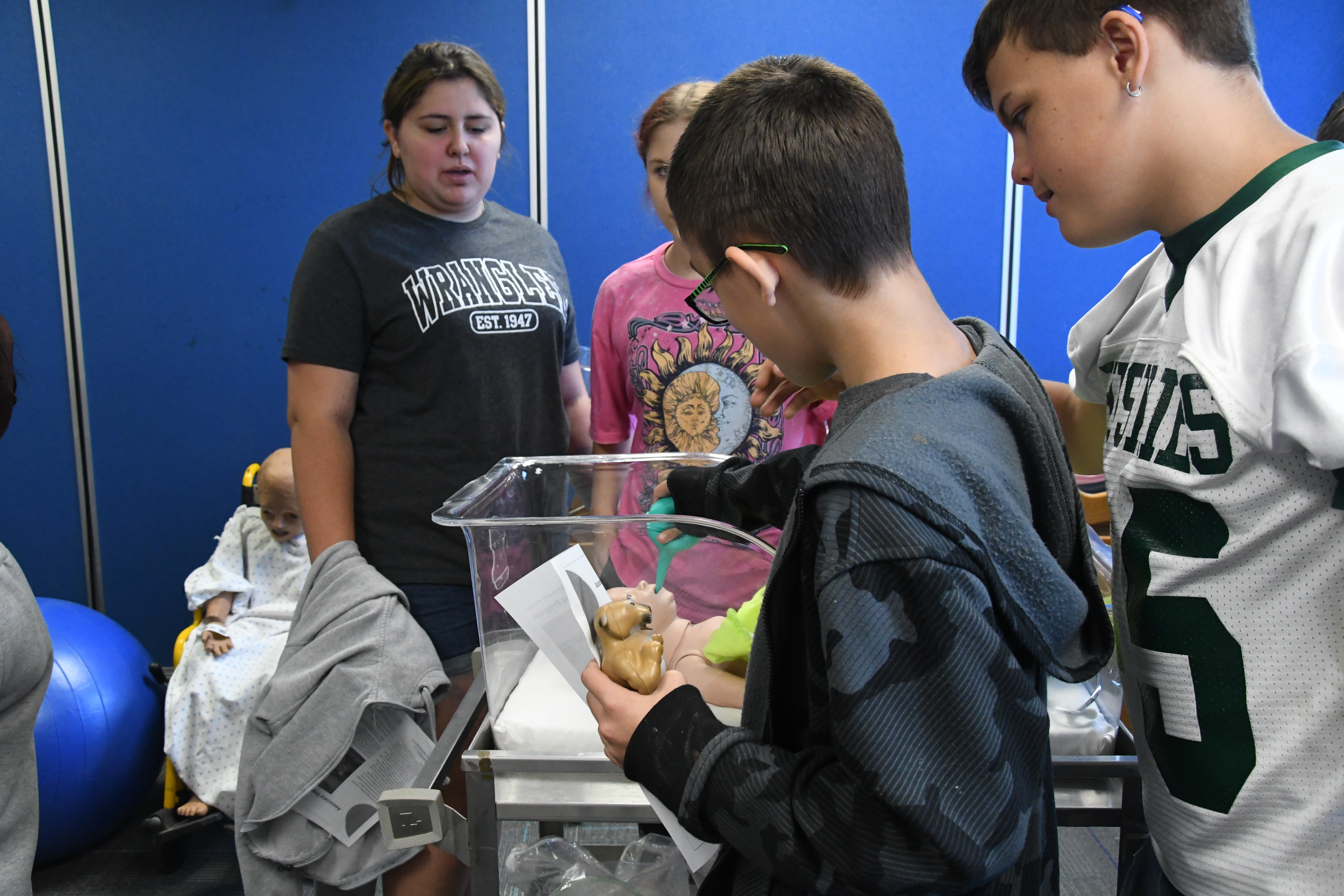 Malone student interacting with a nursing baby animatronic