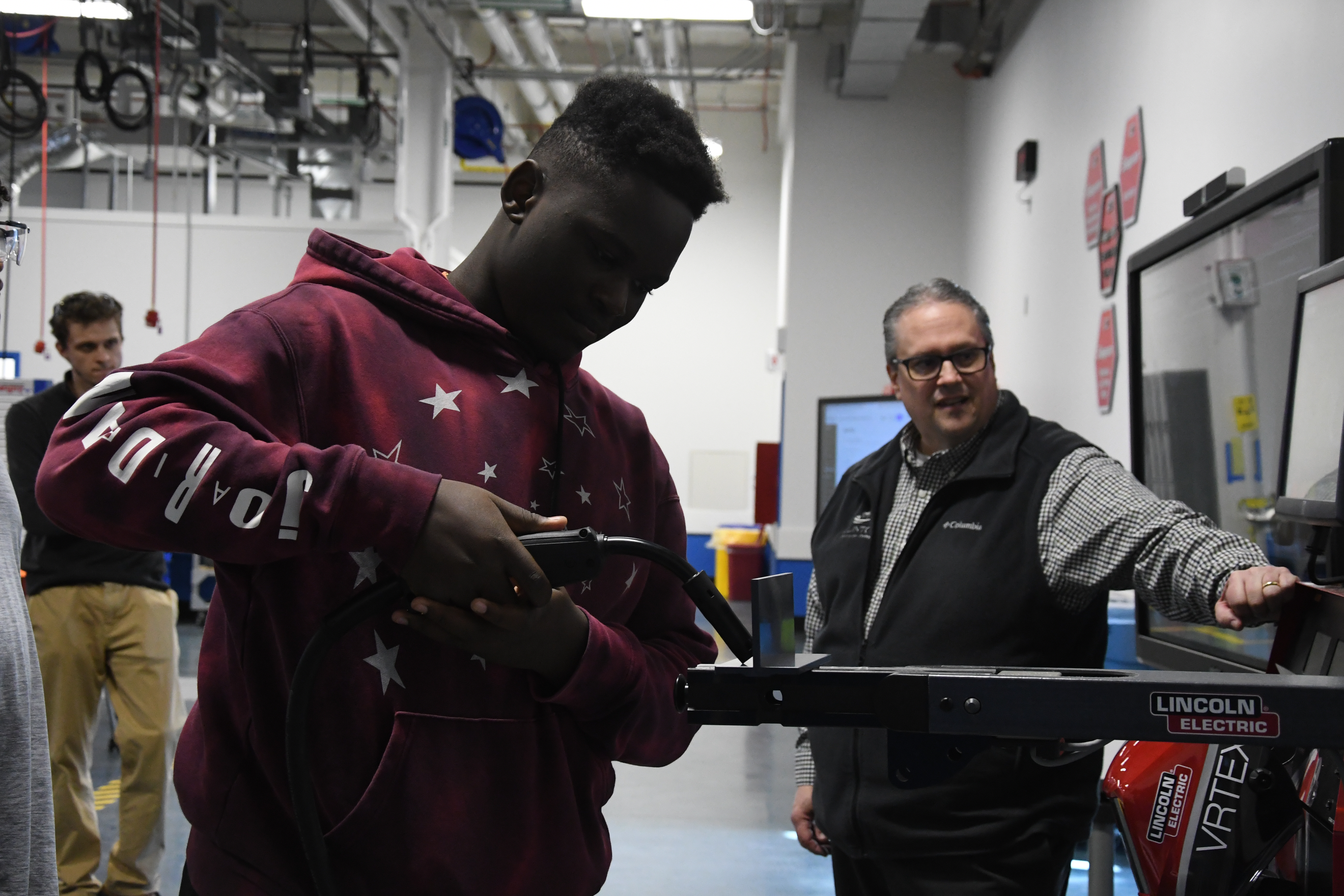 Male student using the welding simulation machine.