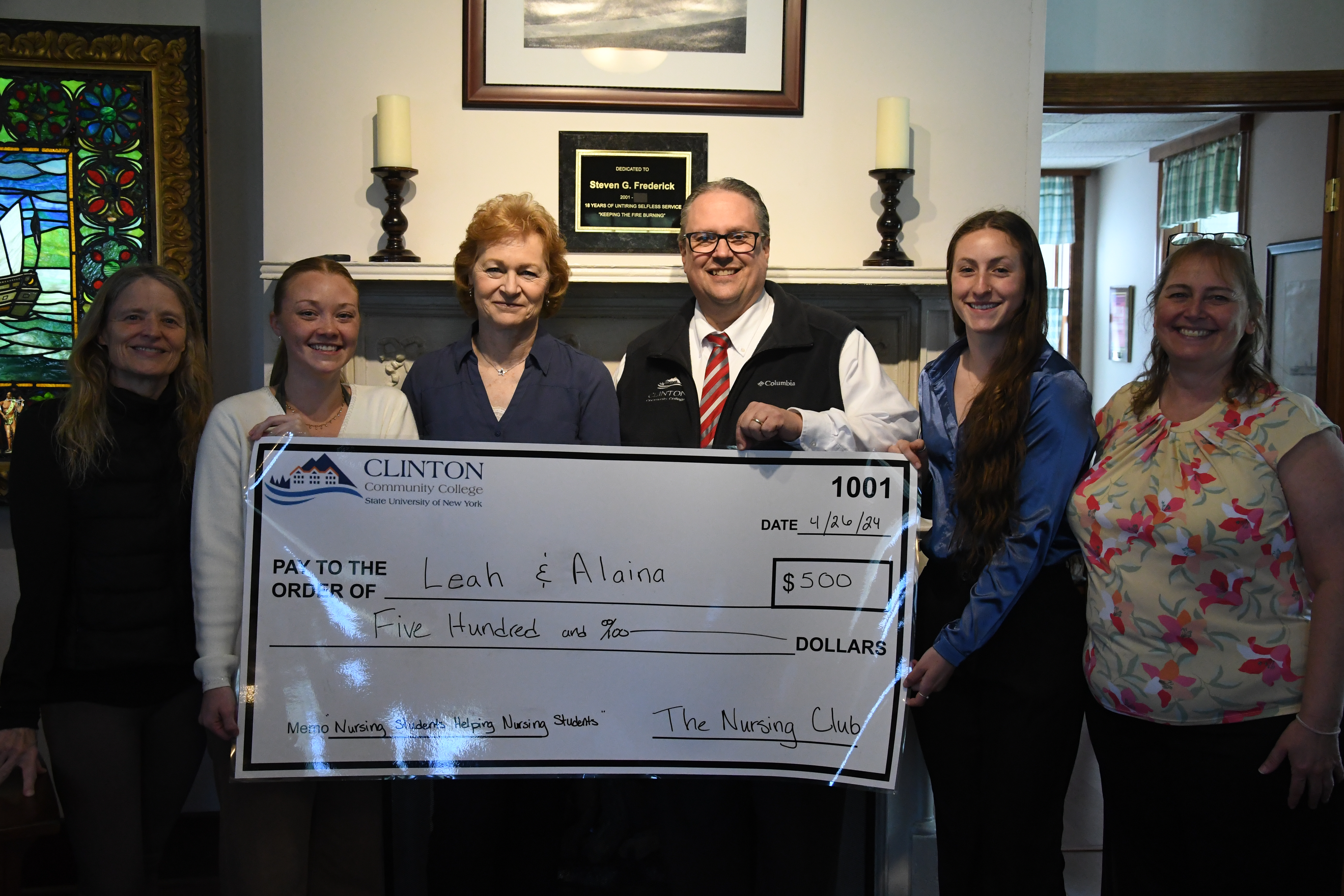 Nursing Club Scholarship recipients, nursing faculty, and Steve Frederick pose for photo with large check.