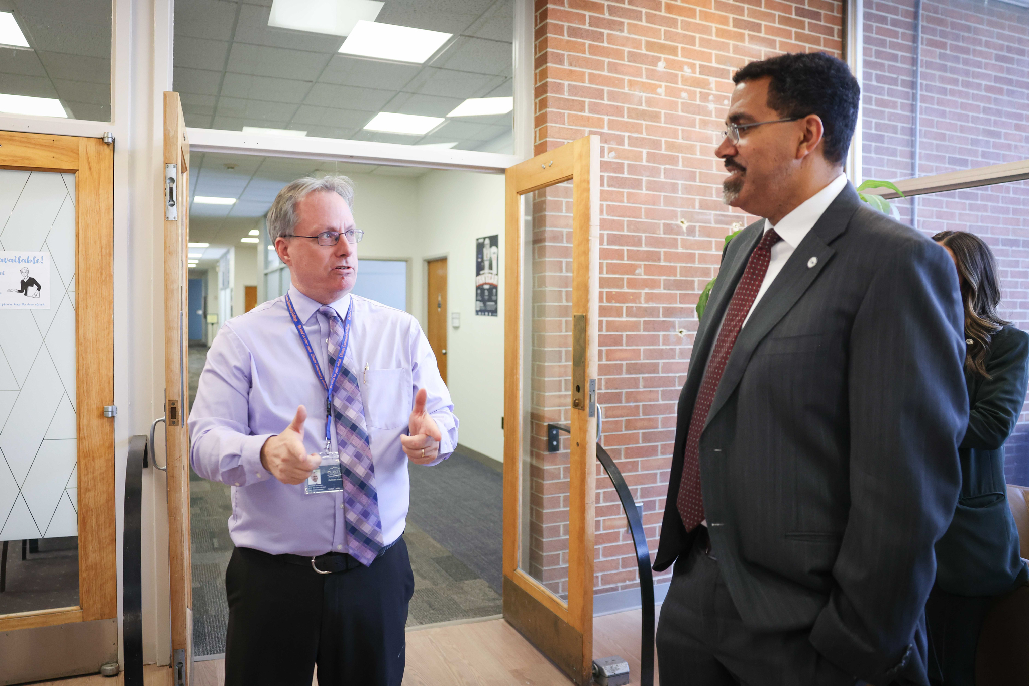 Two people having a conversation in a hallway